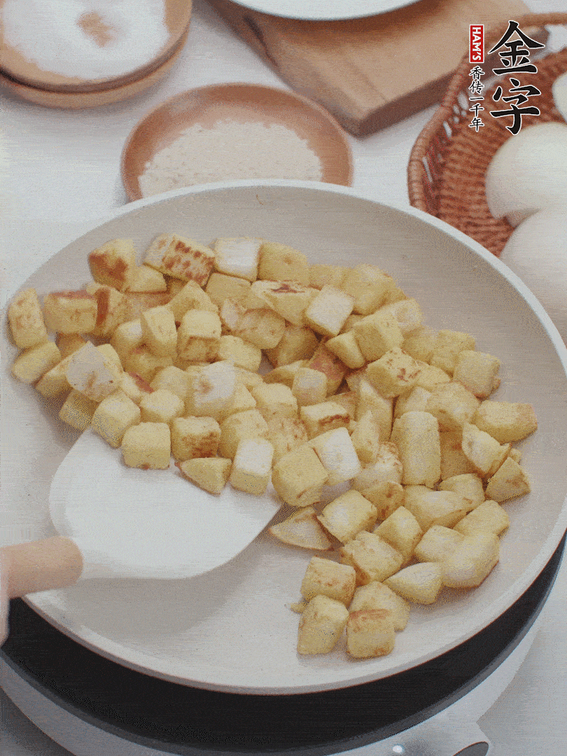 起鍋熱油，倒入饅頭丁，小火煎至蛋液凝固定型再翻面，饅頭丁部煎至金黃時盛起待用。