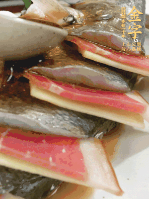 魚肚中塞蔥結(jié)、火腿片，魚身上碼放姜片、火腿片，倒入混合的料汁。